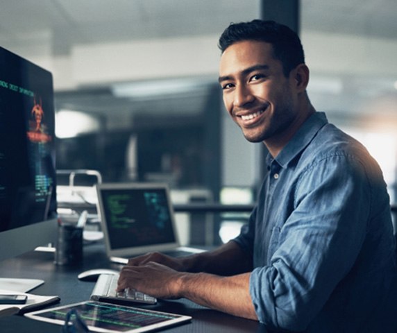 Young professional smiling at his computer