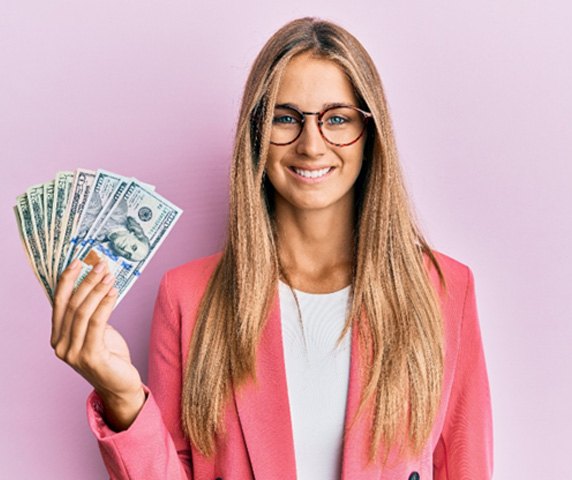 Young woman smiling and holding money