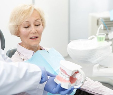 Dentist pointing to a dental model and explaining findings to patient