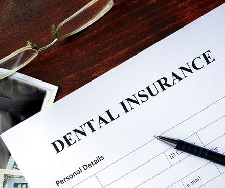 A dental insurance form on a wooden table